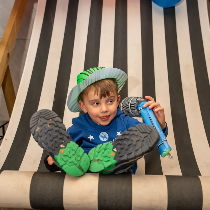Boy with microphone in large deckchair