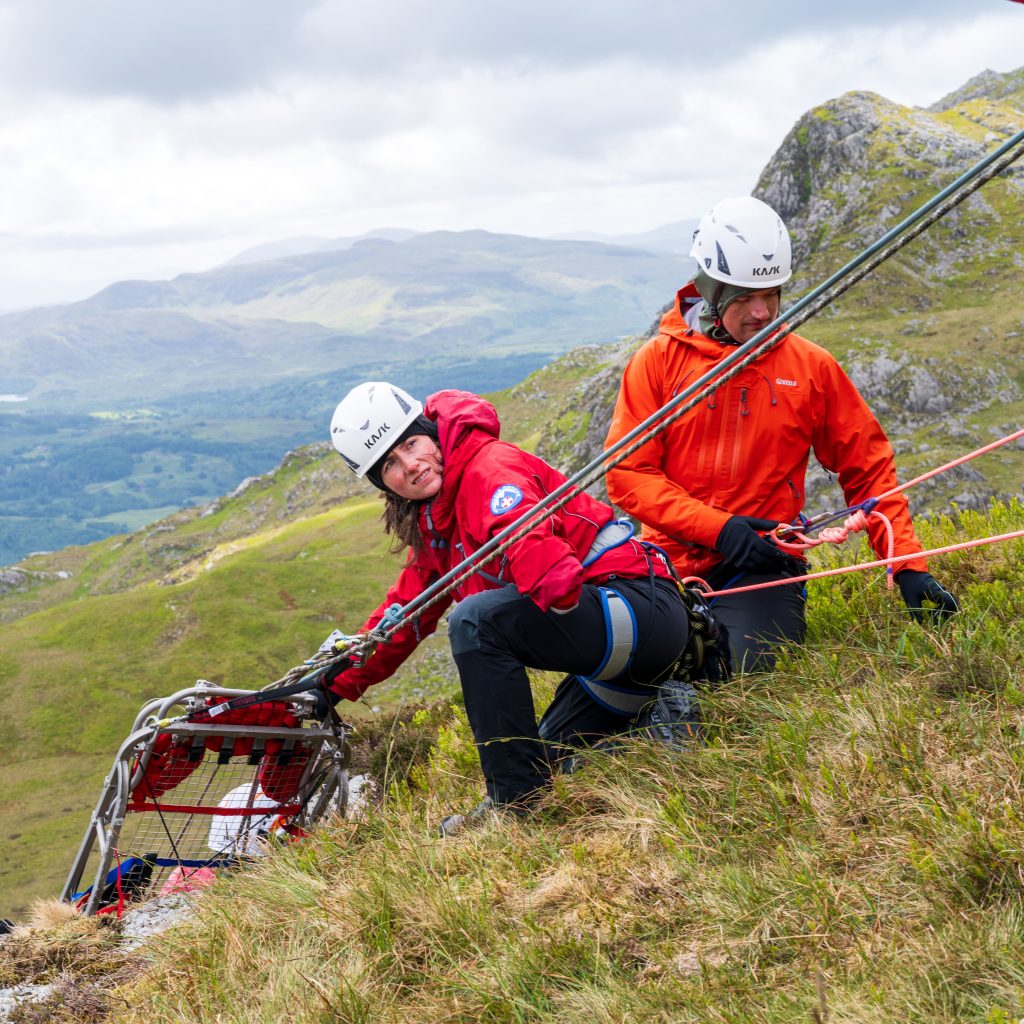 Max with a mountain rescue colleague pulling a stretcher up and over a crag during a training rescue session 